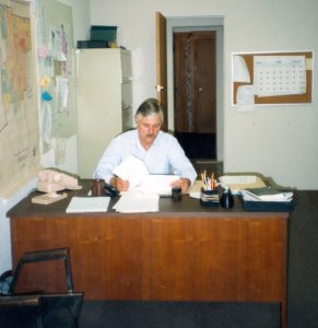 Reville sitting at office desk