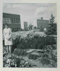 Doreen Befus standing in garden outside instititution.