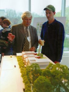 Reville and young man looking at model of housing development