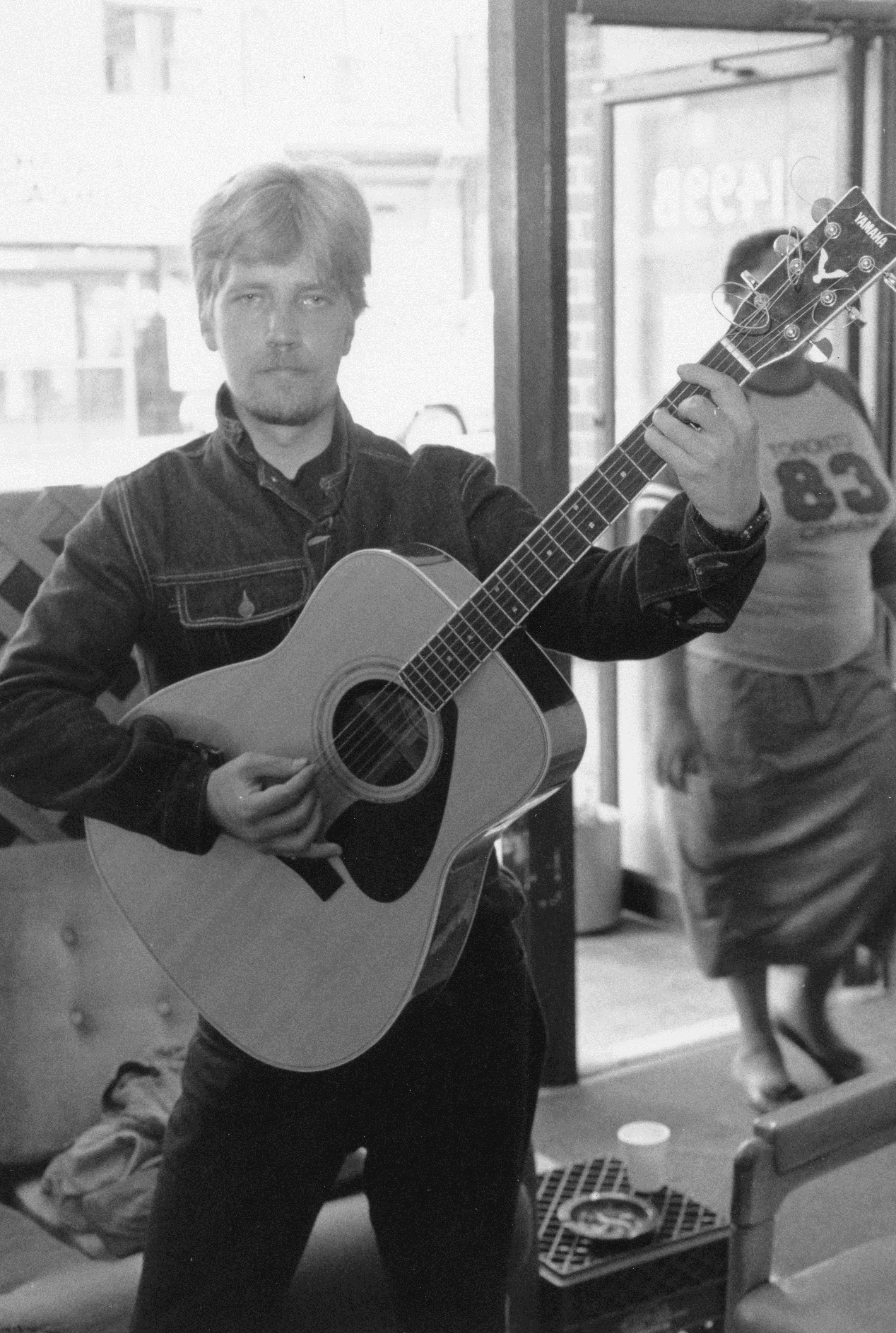 Man at doorway of PARC Drop-In with guitar