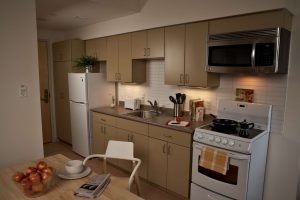 Interior view of apartment in Edmond Place showing table and kitchen area. This looks like a nice place to live.