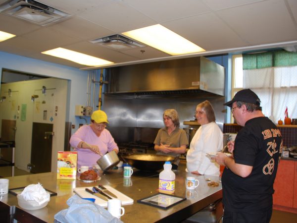 Kitchen photo at PARC with four people preparing food