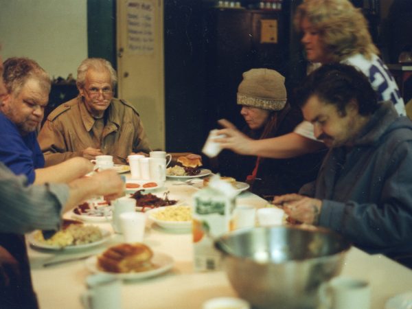 Mealtime photo of group of PARC members sitting around a table eating