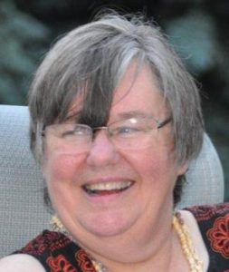 a smiling woman with grey hair and glasses