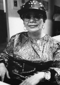 black and white photograph of a woman wearing a baseball cap looking at the camera